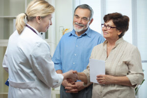 senior couple visiting a doctor for hearing aid benefit