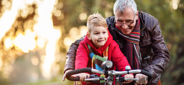 Grandpa teaching his grandkid how to ride a bike