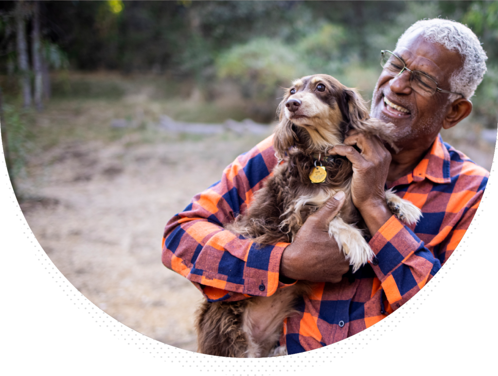 man in flannel shirt outdoors holding small dog