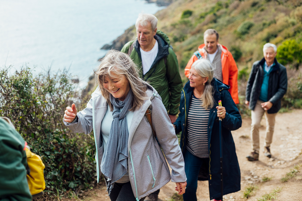 Group of older people on a hike near the water.